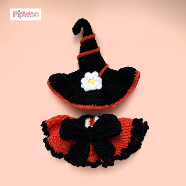 Flat lay of Crochet Labubu Clothes – Halloween Witch showing the orange-and-black dress with bow and heart motif alongside the matching pointed witch hat.